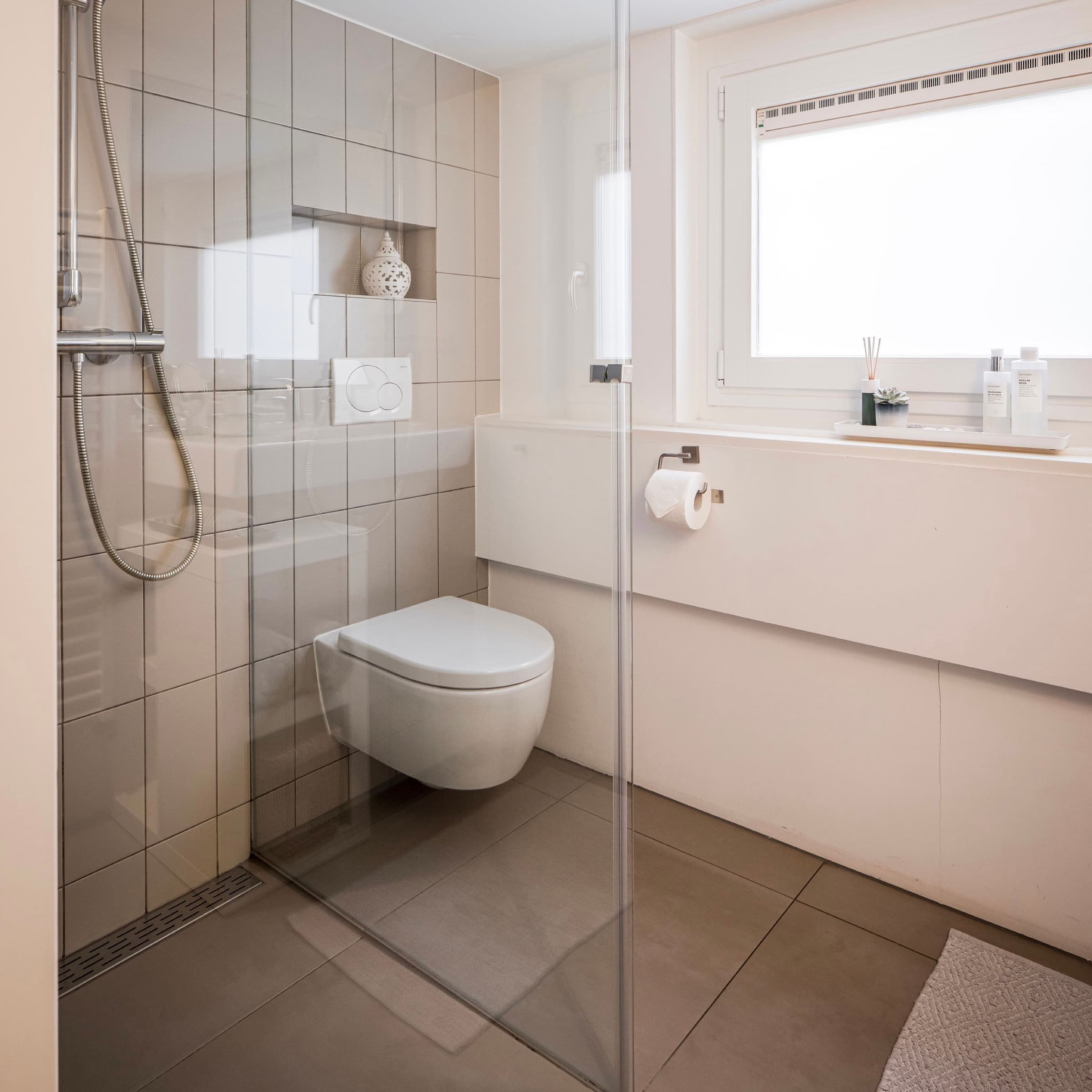 Luminoso baño en la planta superior de la casa privada Romantic Wellness B&B en Noordwijk, con ducha a ras de suelo e inodoro suspendido.