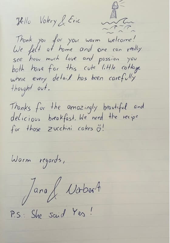 Handwritten guestbook review thanking Valery and Eric for their warm welcome, thoughtful guesthouse and breakfast, with a small lighthouse drawing.