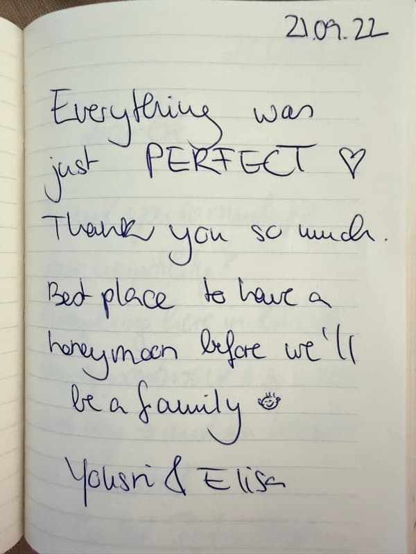 English honeymoon guestbook note saying everything was perfect, decorated with a heart and a smiling face.