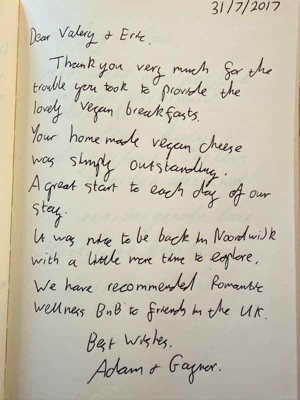 Handwritten English guestbook review praising the home made vegan breakfast and recommending Romantic Wellness B&B to friends.