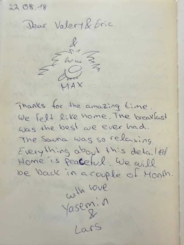 Handwritten English guestbook note praising the breakfast, sauna and peaceful home, beneath a playful drawing of Max the dog.