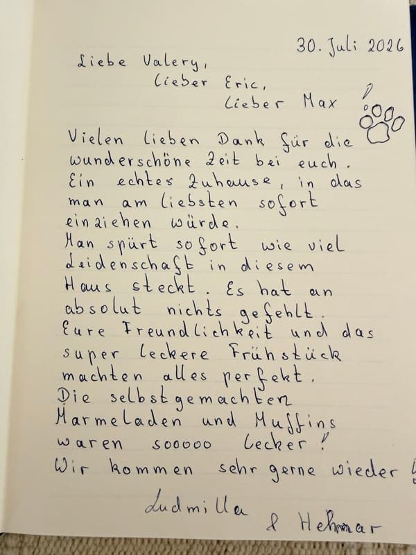 Handwritten German guestbook note praising the homely summer house, warm welcome and home made jams and muffins, with a paw print for Max.