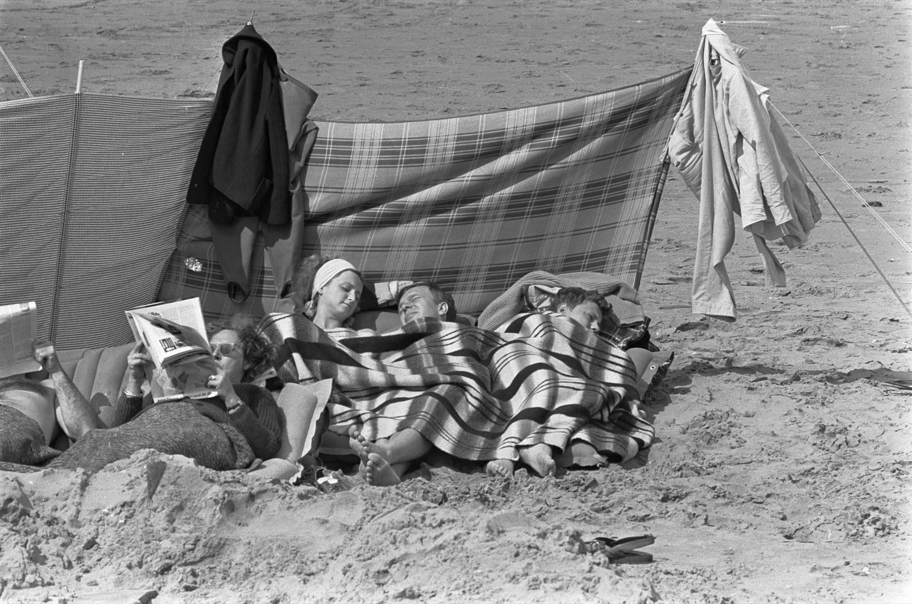 Badegäste am Noordwijker Strand ruhen am 2. August 1966 unter gestreiften Wolldecken hinter einem Windschutz.