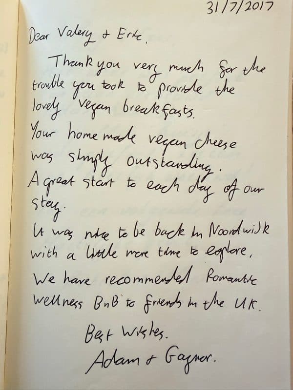 Handwritten English guestbook review praising the home made vegan breakfast and recommending Romantic Wellness B&B to friends.
