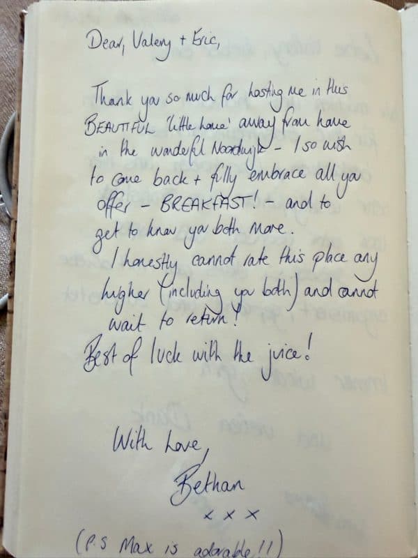 Handwritten English guestbook note praising the beautiful little home, breakfast and hosts, with a postscript about Max the dog.