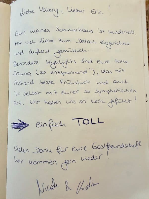 Handgeschriebene deutsche Gästebuchbewertung, die das gemütliche Sommerhaus, die Sauna, das Frühstück und die Gastgeber lobt, mit einem kräftigen Pfeil auf „einfach TOLL“.
