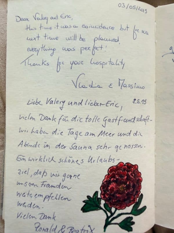 Two handwritten guestbook notes in English and German thanking the hosts for their hospitality, beach days and sauna evenings, beside a red flower drawing.