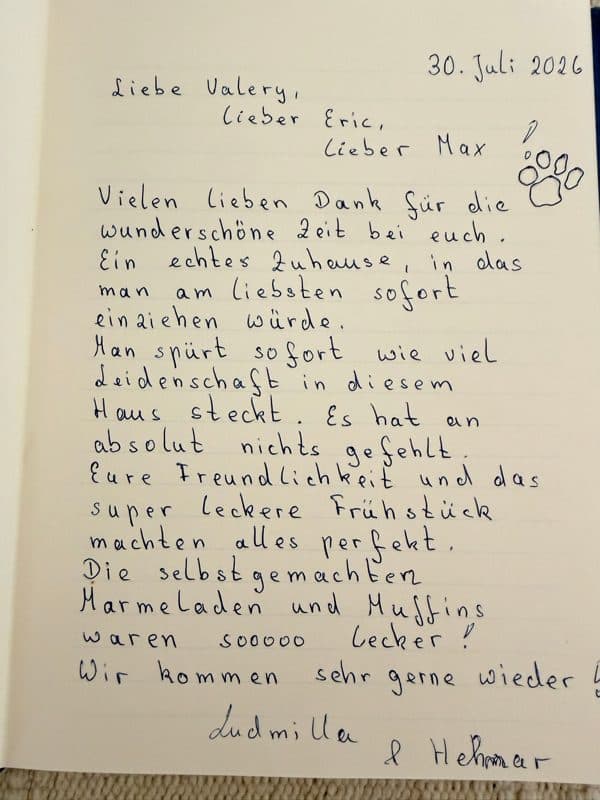 Handwritten German guestbook note praising the homely summer house, warm welcome and home made jams and muffins, with a paw print for Max.